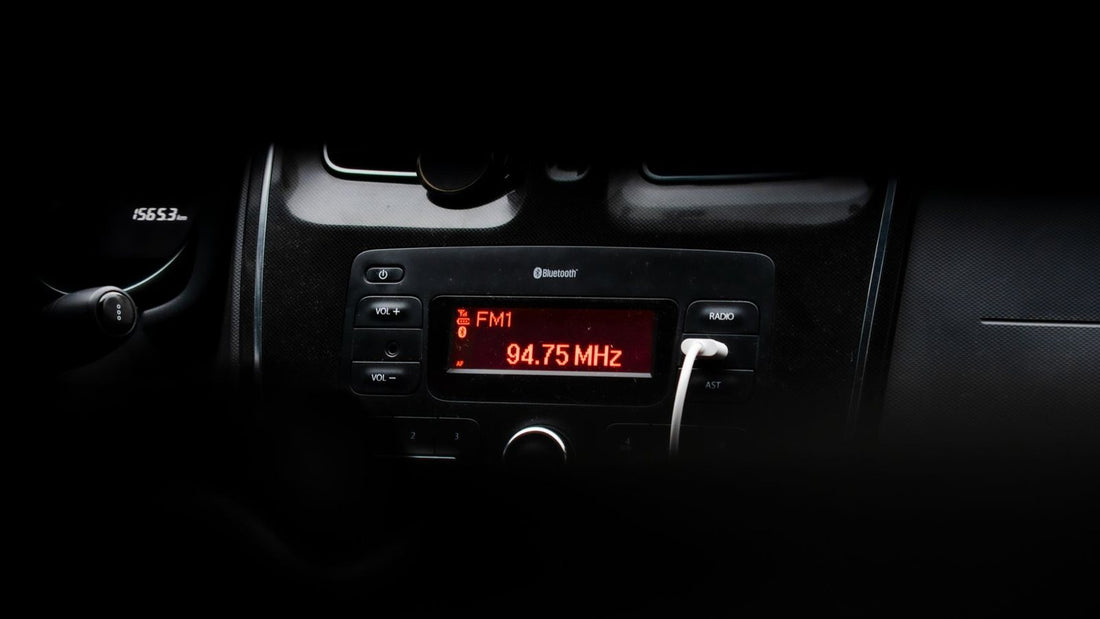 Car radio display lit in a darkened dashboard