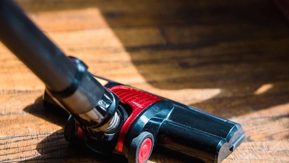 Cordless vacuum cleaner head resting on a wooden floor