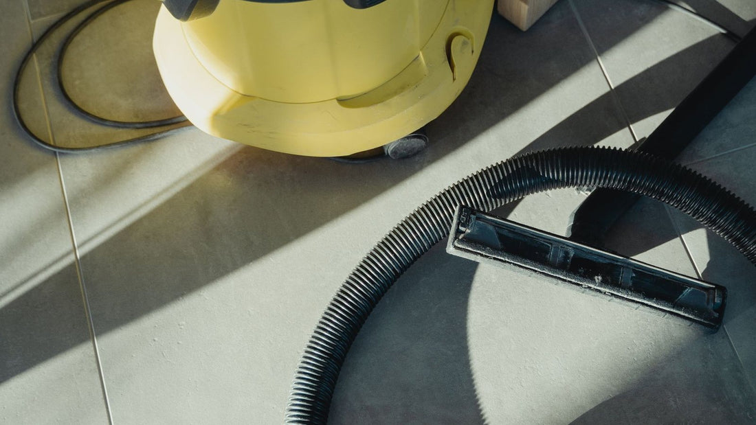 Vacuum cleaner and hose on a tiled floor