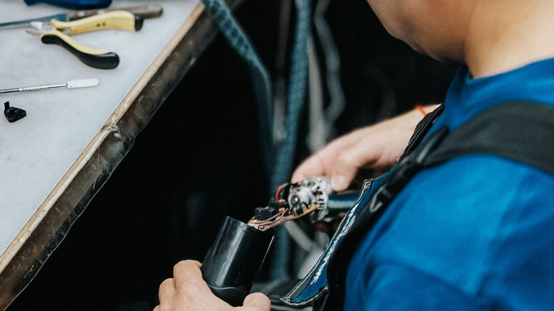 Repair technician working on an electronic device at a bench
