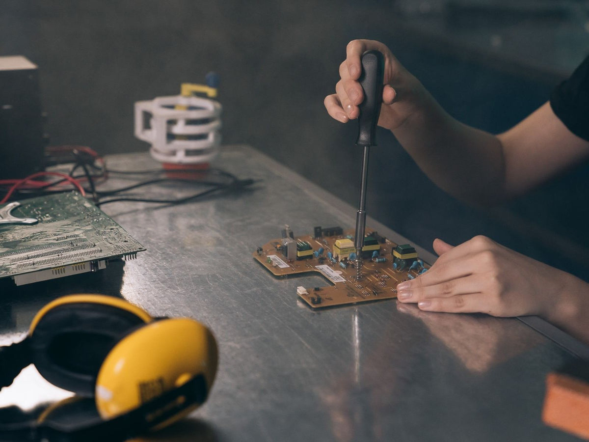 Hand tools and electronic components laid out on a repair bench