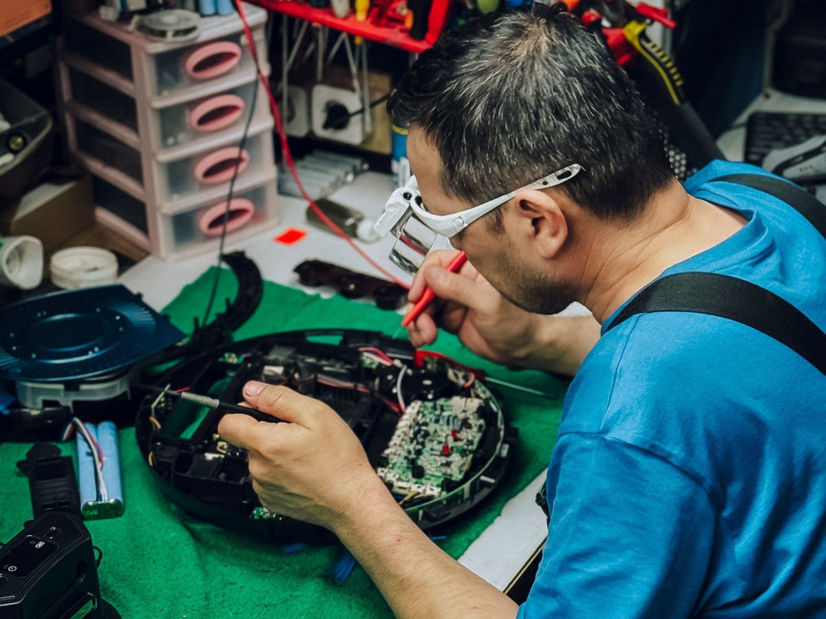 Repair technician working at a bench in an electronics workshop